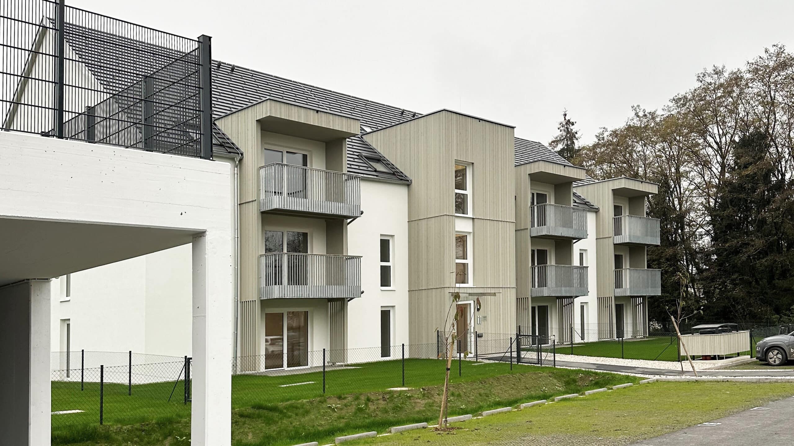 Wohnbau in Massivholz mit Balkonen und Terrassen, Holzfassade, Balkone mit Metallgeländer, Vorvergrautes Holz