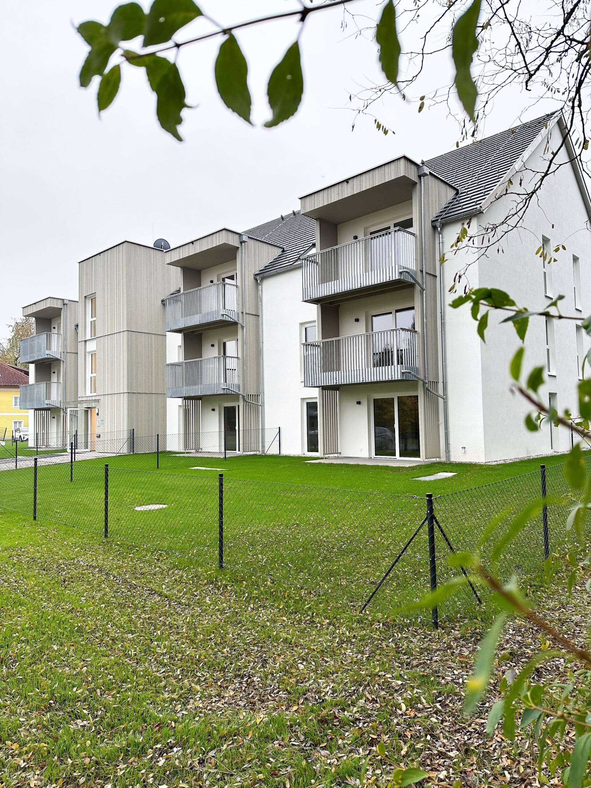 Wohnbau in Massivholz mit Balkonen und Terrassen, Holzfassade, Balkone mit Metallgeländer, Vorvergrautes Holz