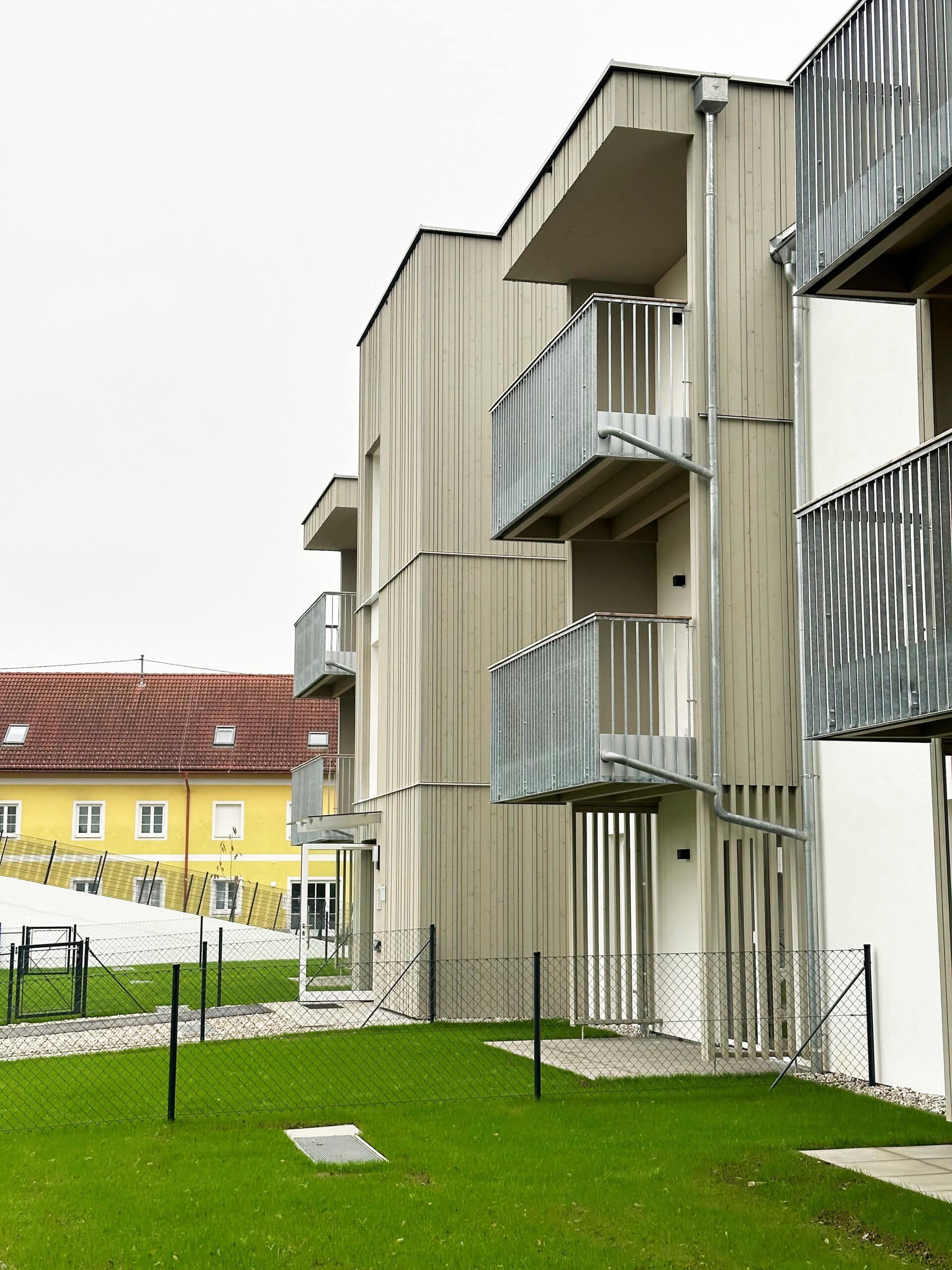 Wohnbau in Massivholz; Balkone mit Metallgeländer, Holzfassade, Moderne Architektur