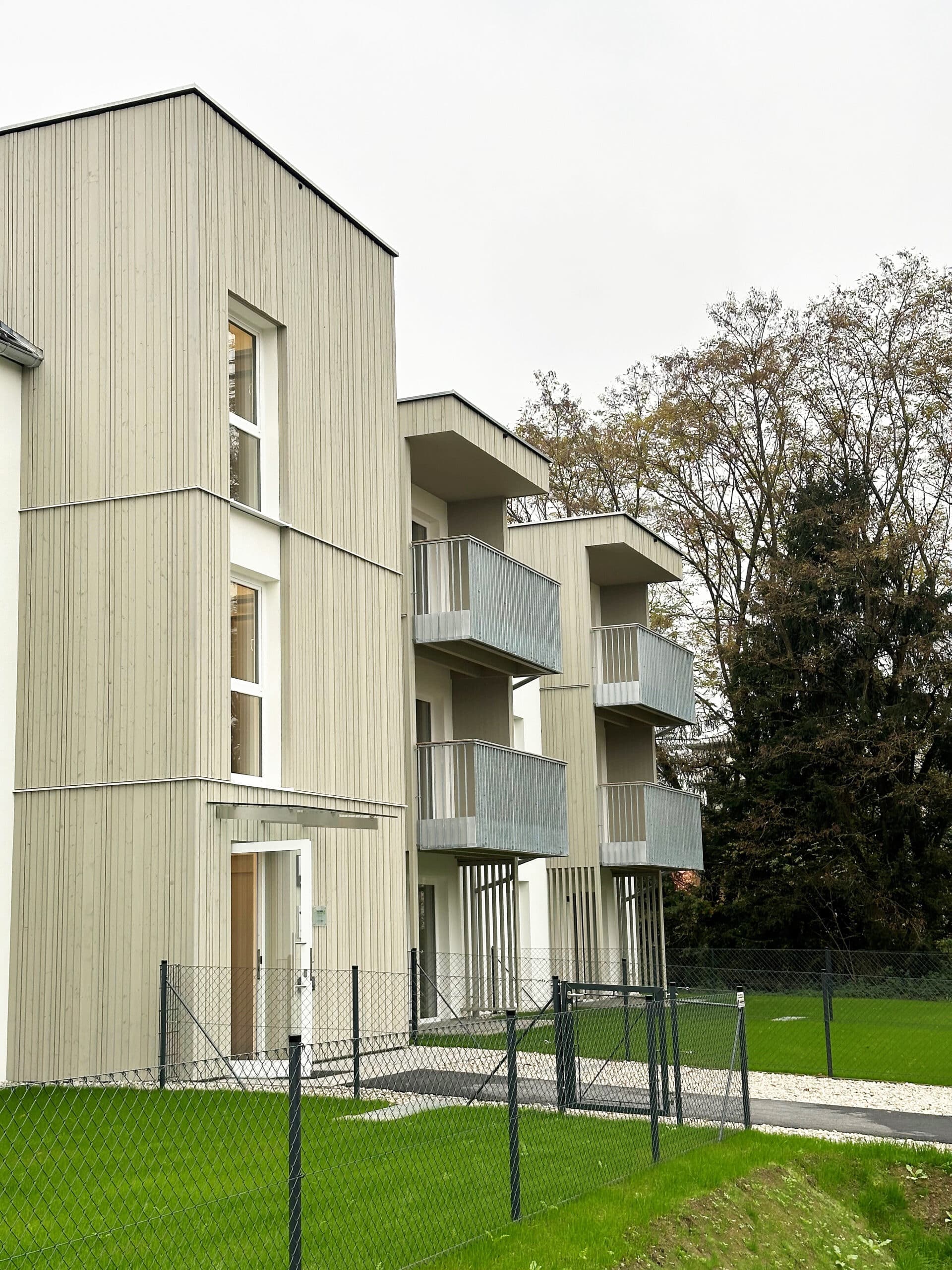 Wohnbau in Massivholz mit Balkonen und Terrassen, Holzfassade, Balkone mit Metallgeländer, Vorvergrautes Holz