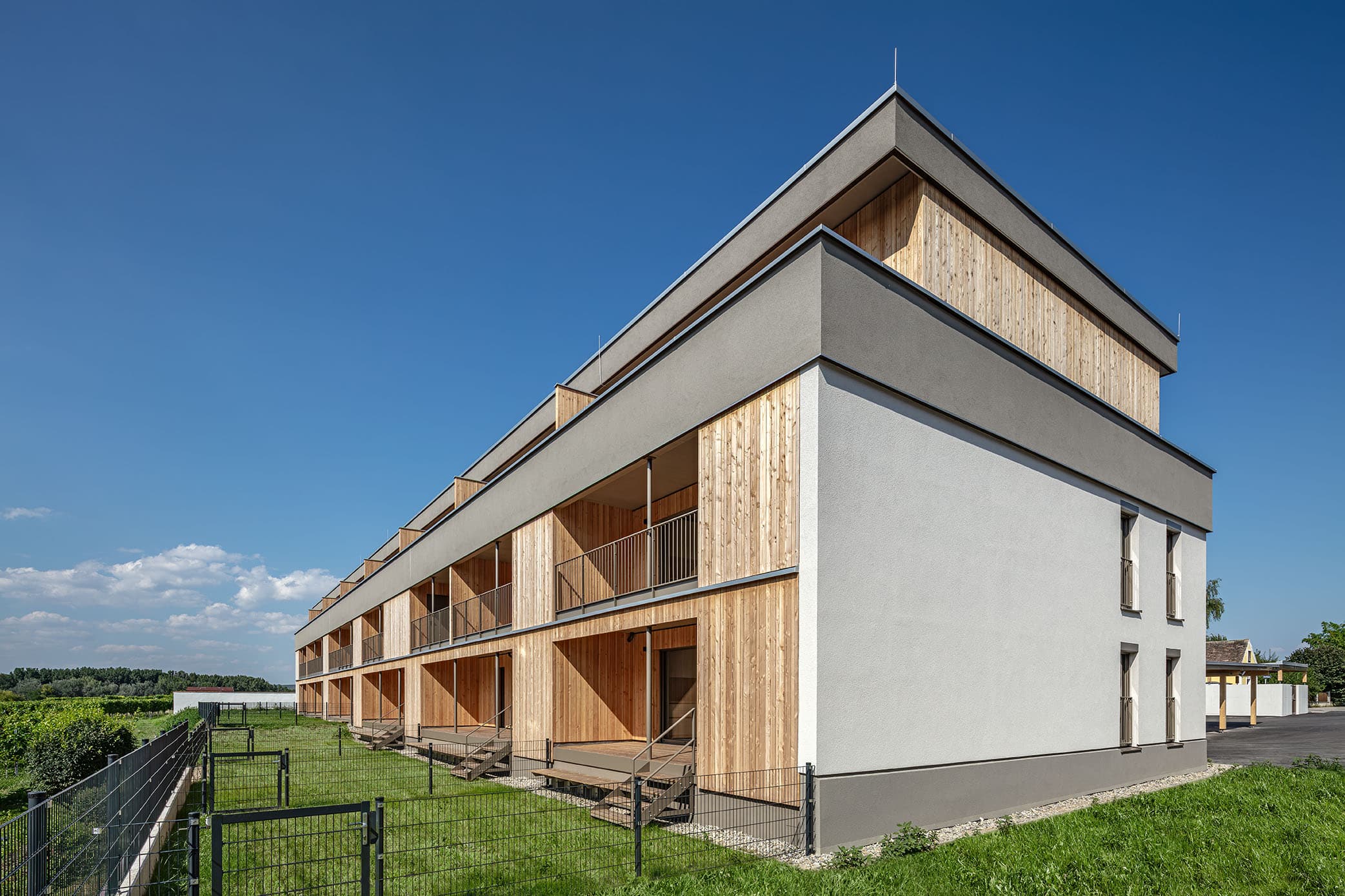 Massivholzwohnbau in Brunnkirchen. Terrassen und Balkone mit Holzfassade